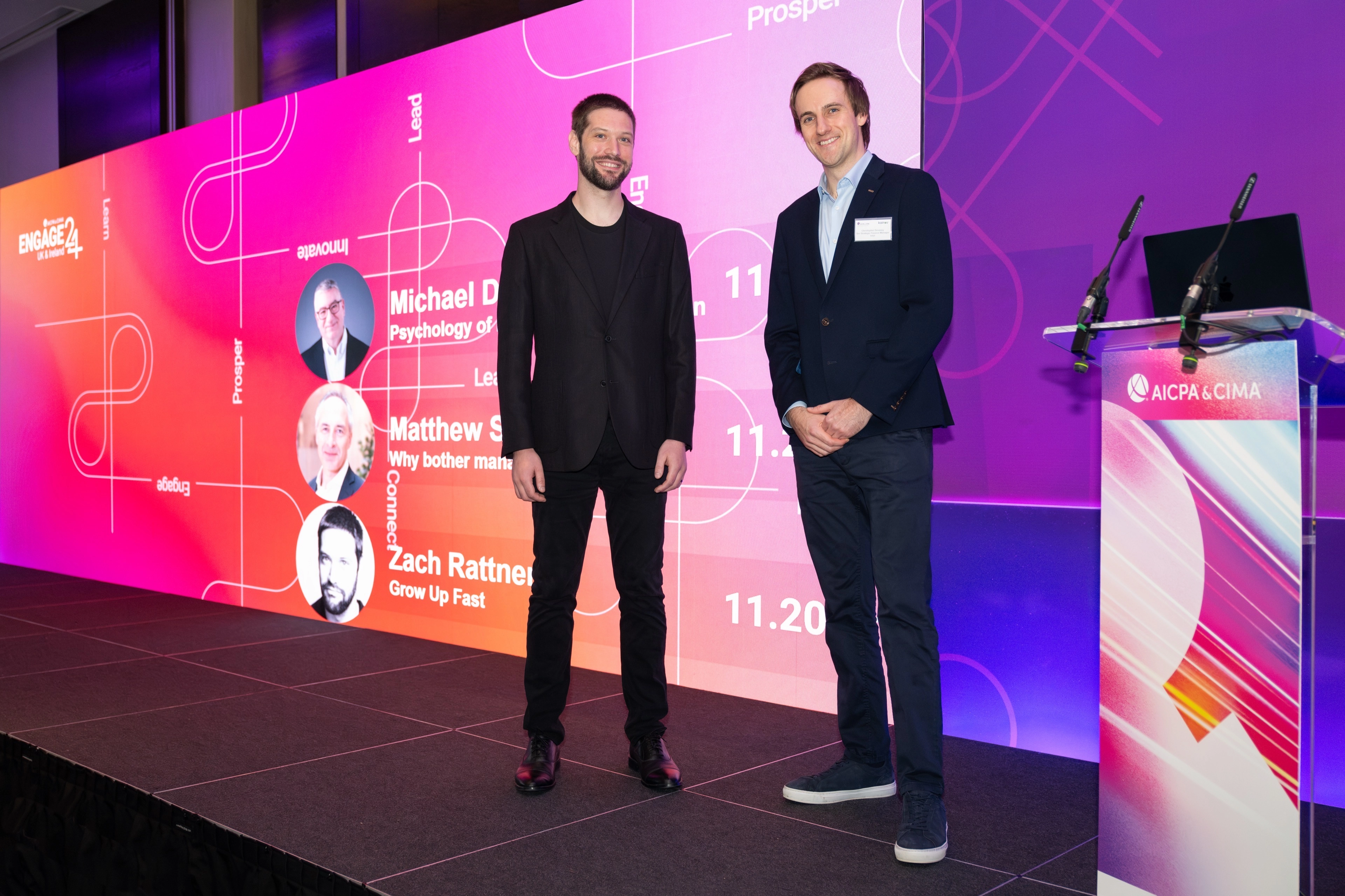 A professional presenting on stage at Engage 24 to an audience seated at round tables