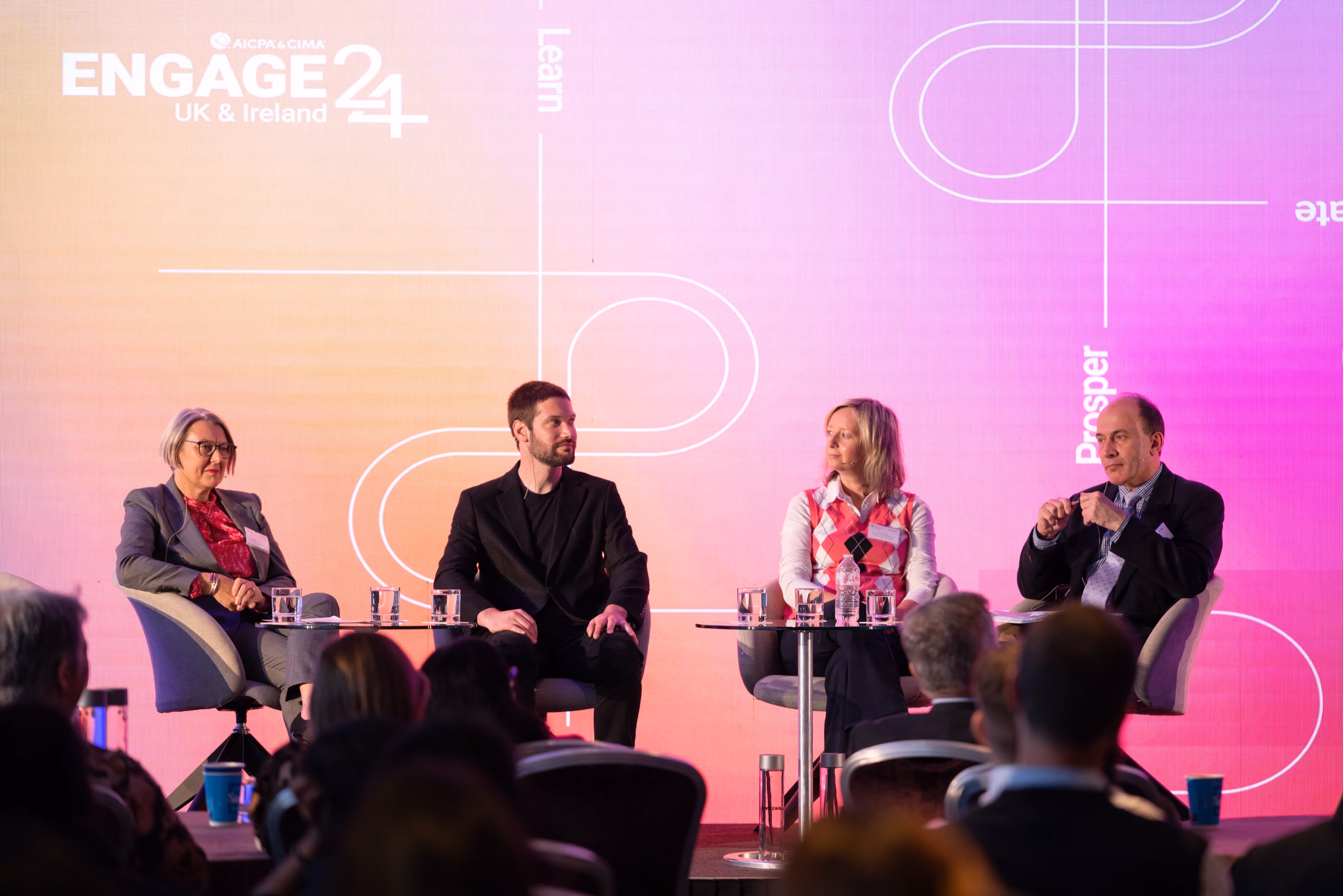 Four professionals including Zach Rattner participating in a panel discussion on a brightly lit stage at the AICPA and CIMA ENGAGE 24 conference.