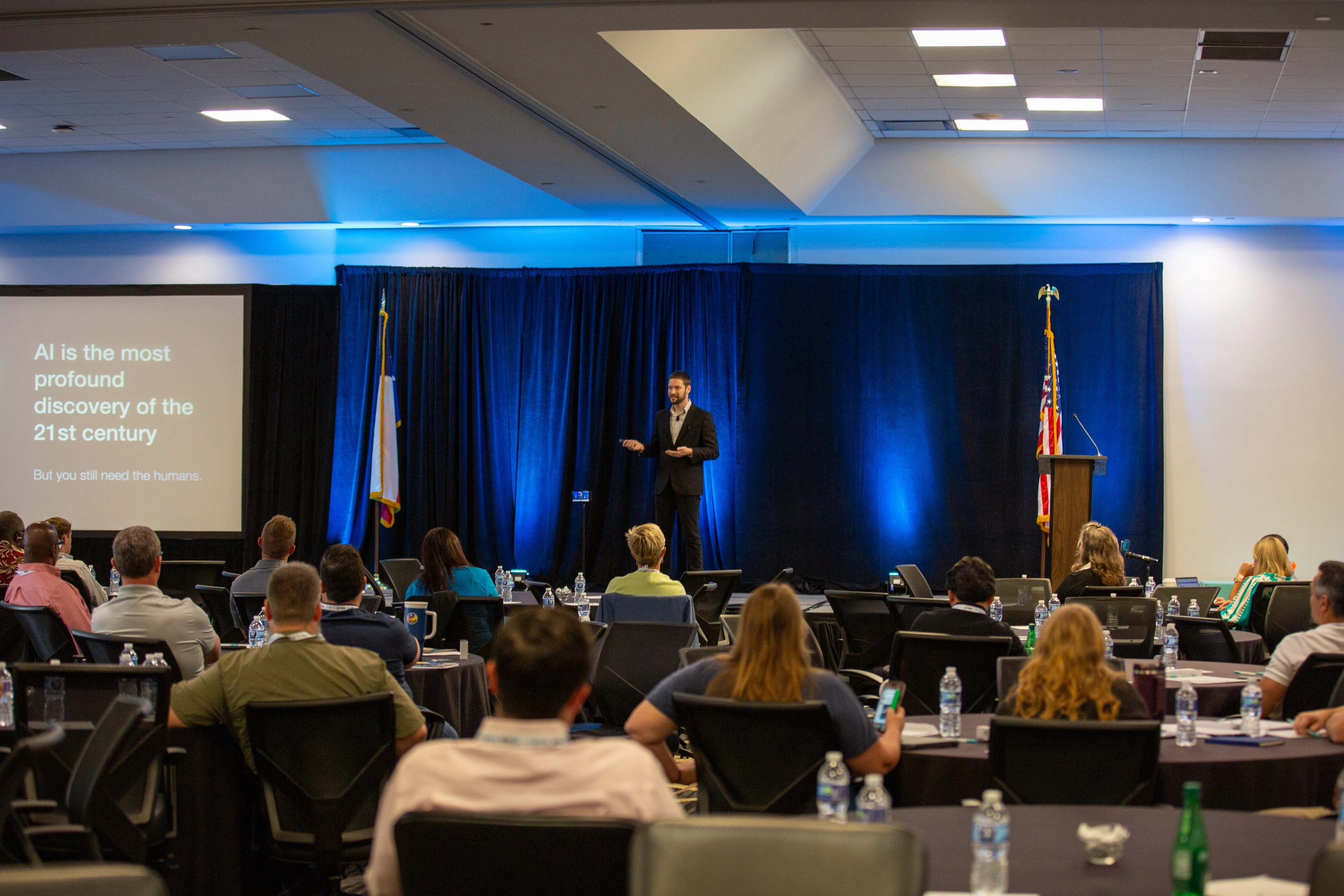 A professional presenting on stage to an audience
